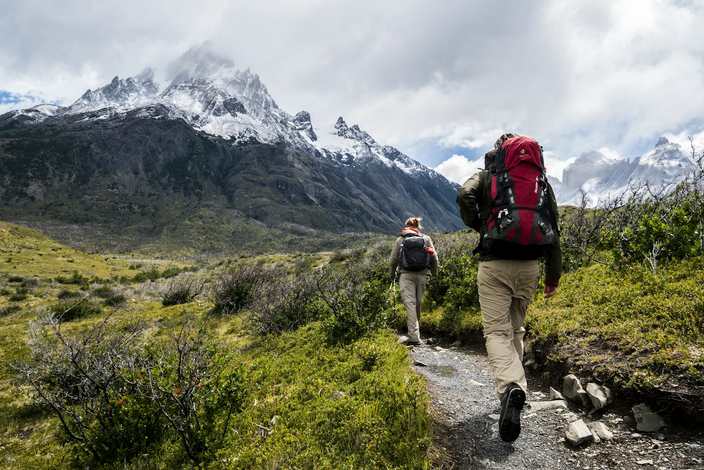 Backpackers carrying loaded packs through mountain terrain